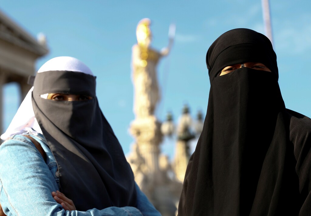 Demonstrators covering their faces participate in a protest called "The traditional clown's walk against the burqa ban" in Vienna, Austria October 1, 2017. REUTERS/Leonhard Foeger - RC1F47DF98D0