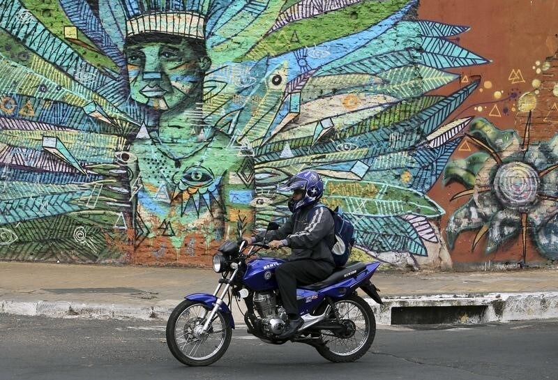 A motorcyclist rides past a wall of graffiti in Asuncion June 25, 2012.