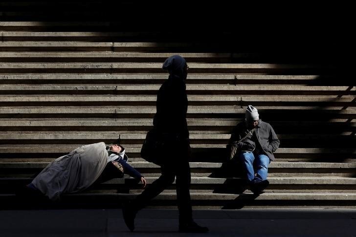 A homeless person (L) sleeps on the steps of Federal Hall on Wall St. in New York City, U.S., February 28, 2017. REUTERS/Brendan McDermid