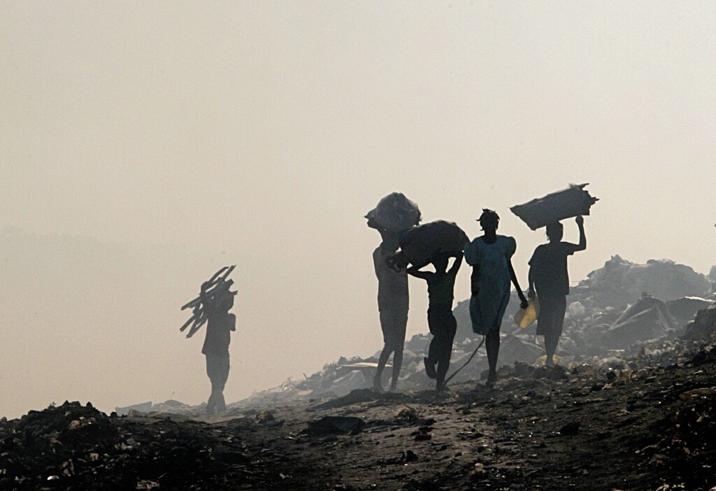 people walk away from the camera carrying debris