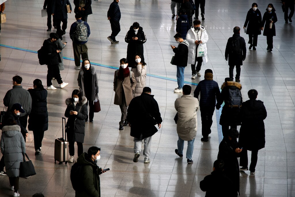 People wearing masks to prevent contracting the coronavirus disease (COVID-19) walk at a railway station in Seoul, South Korea, January 5, 2022. REUTERS/Heo Ran