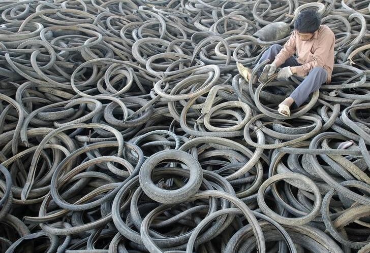 A labourer recycles rubber from old tyres at a garbage dump site in Yingtan, east China's Jiangxi province October 4, 2007. Tyre makers are scouring for rubber to replenish stocks but main buyer China may wait for prices to fall before jumping into the market, dealers said. REUTERS/Stringer (CHINA) CHINA OUT