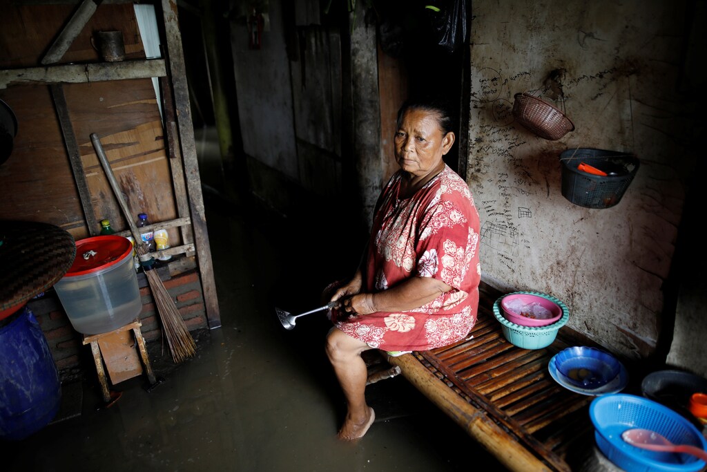 Sainah sits in the kitchen area of her home, flooded by sea water, near Pantai Bahagia in Bekasi, West Java province, Indonesia, February 1, 2018. REUTERS/Darren Whiteside SEARCH "COASTLINE INDONESIA" FOR THIS STORY. SEARCH "WIDER IMAGE" FOR ALL STORIES. - RC1D7CEF96E0