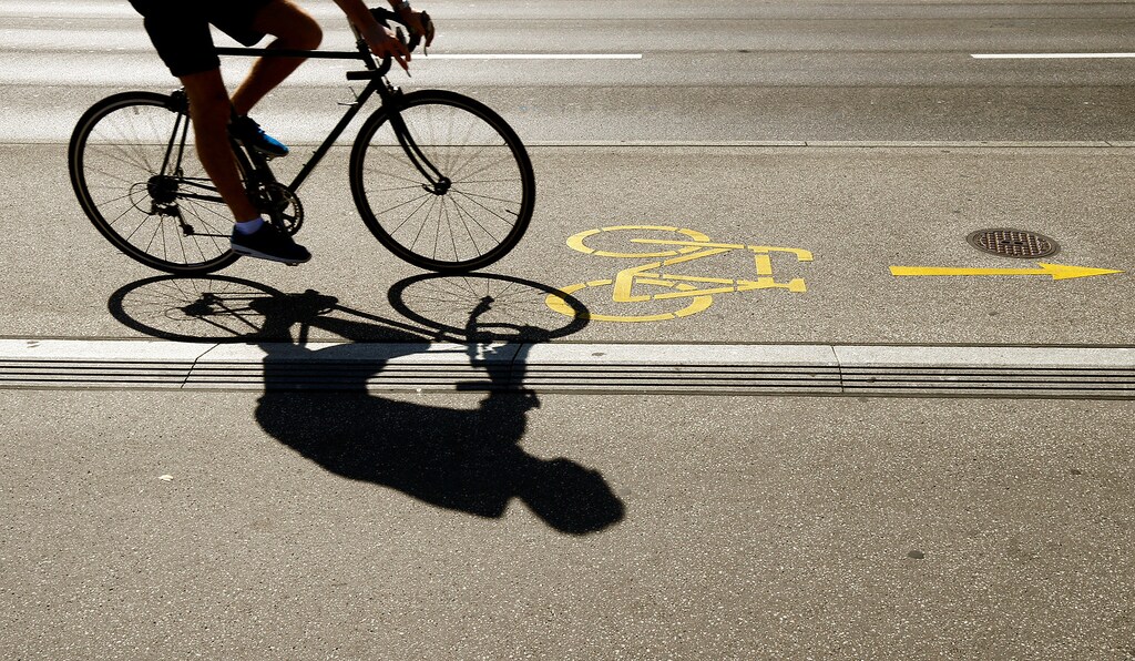 The silhouette of a cyclist is seen on a bike lane in Zurich, Switzerland August 29, 2017. REUTERS/Arnd Wiegmann - RC149E55FC60