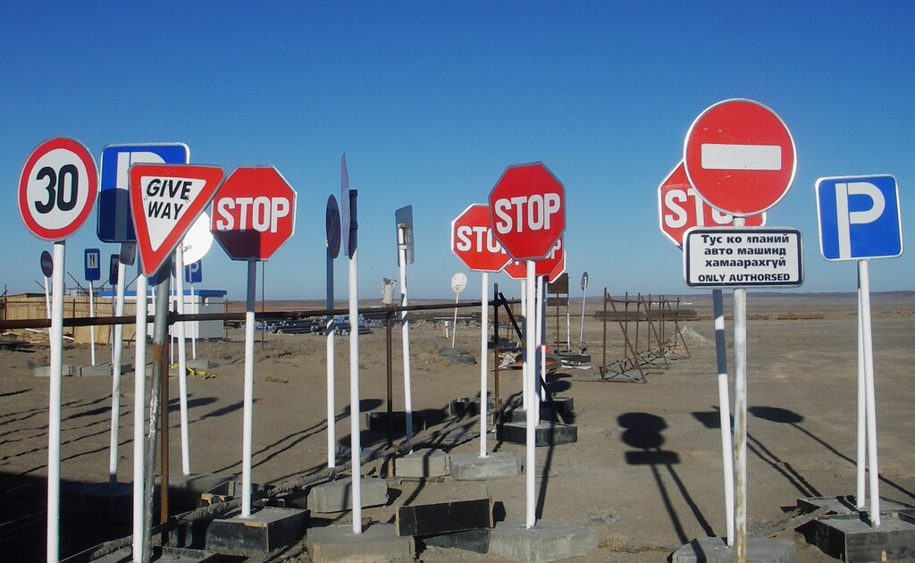 Road signs stand in Mongolia's South Gobi desert, awaiting to be deployed during the development of Oyu Tolgoi copper and gold mine in Mongolia November 10, 2007. Mining firms are telling Mongolia's parliament to unlock the country's mining sector by taking a landmark decision on a multi-billion dollar copper deal. Oyu Tolgoi's potential was enough to make geologists' eyes bulge on a recent tour of the site, where traditional Mongolian white tents stand alongside thousands of crates containing 720 km of drill core -- rock drilled out during the exploration phase. Picture taken November 10, 2007. REUTERS/Tom Miles (MONGOLIA)