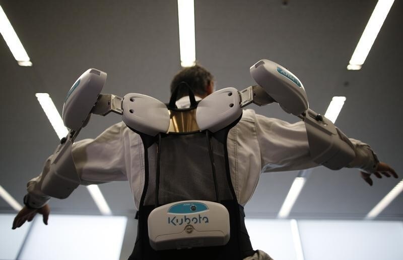An employee of ActiveLink Co. established under the intrapreneurship of Panasonic Corp, demonstrates ARM01, called 'Raku Vest', jointly developed with Kubota Corp., in Tokyo June 2, 2014. The ARM01is a robotic exoskeleton developed to help farmers and construction workers. REUTERS/Issei Kato (JAPAN - Tags: SCIENCE TECHNOLOGY SOCIETY BUSINESS TPX IMAGES OF THE DAY) - RTR3RSJQ