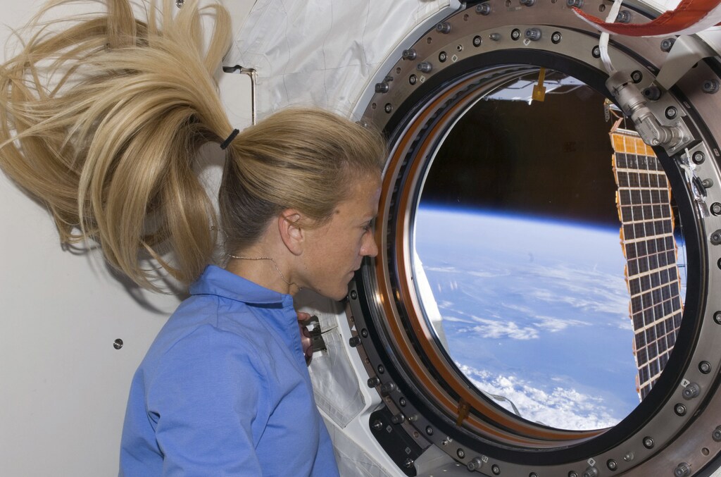Astronaut Karen Nyberg looks through a window in the newly installed Kibo laboratory of the International Space Station while Space Shuttle Discovery is docked with the station in this photo released by NASA June 11, 2008
