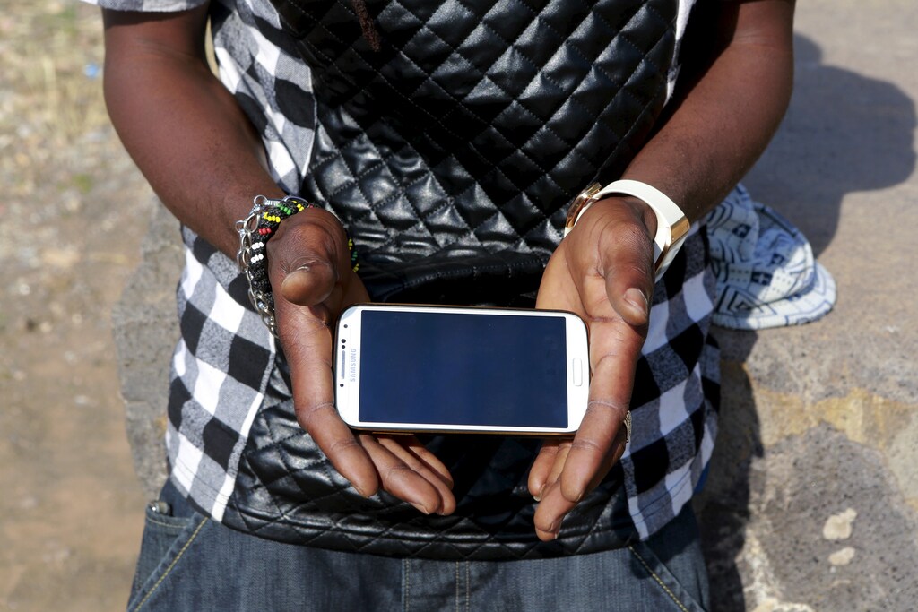 Said Youssef, 30, a rapper from Ghana, holds his mobile phone in the town of Oujda, northern Morocco, June 11, 2015. Youssef aims to cross the border into Spain's north African enclave of Melilla and realize his dream of becoming professional singer. REUTERS/Youssef Boudlal? - RTX1H40S