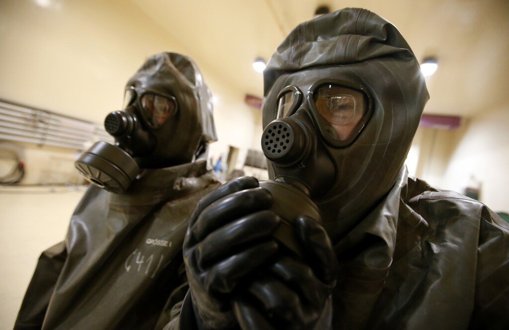 An employee checks his gasmask before decontaminating a military vehicle in the nuclear department at the Research Institute for Protective Technologies, Nuclear, Biological and Chemical Protection (WIS) during a demonstration in Munster October 15, 2013. The state-owned WIS is a reference laboratory for the Organisation for the Prohibition of Chemical Weapons (OPCW). Picture taken October 15, 2013. REUTERS/Fabrizio Bensch (GERMANY - Tags: MILITARY SCIENCE TECHNOLOGY) - BM2E9AG10WY01