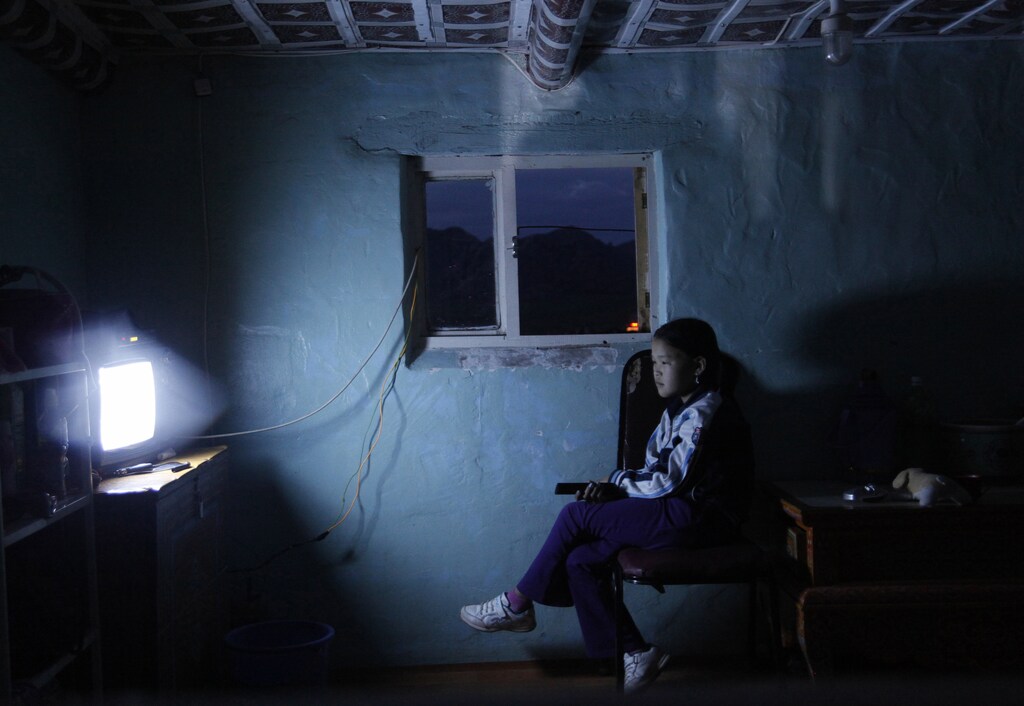 A Mongolian girl watches television in a house at a tourist campsite in Mongolia's Bulgan province August 11, 2011. Picture taken August 11, 2011. REUTERS/Laurence Tan (MONGOLIA - Tags: SOCIETY TRAVEL) - RTR2RDRY