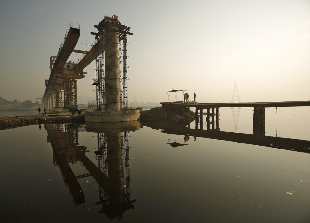 Labourers work at the construction site of a bridge being built over the river Yamuna for metro rail in New Delhi December 12, 2014. With growth struggling at 5.3 percent in the July-September quarter, it is likely to be some time before India recaptures the 8 percent growth levels needed to create enough jobs for a rapidly expanding workforce. REUTERS/Anindito Mukherjee (INDIA - Tags: BUSINESS CONSTRUCTION) - GM1EACC185M01