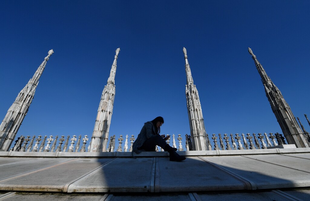 A woman sits in the shadow during a visit to the Milan's Duomo cathedral, as it reopened to the public after coronavirus disease (COVID-19) restrictions were eased, in Milan, Italy, February 11, 2021. REUTERS/Daniele Mascolo TPX IMAGES OF THE DAY - RC2BQL93EA9G