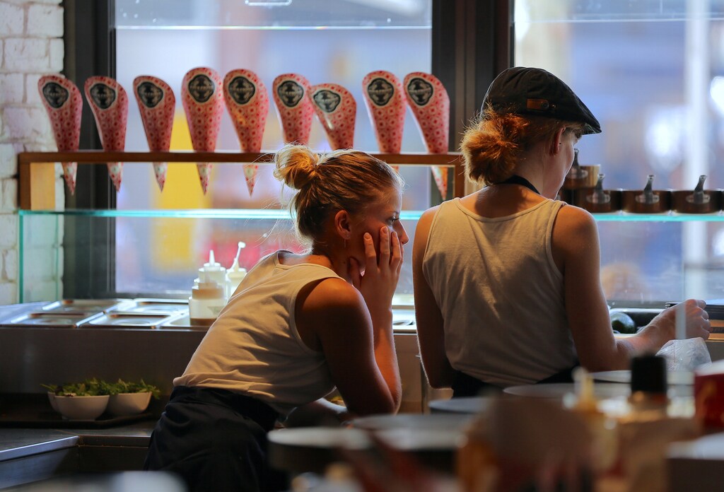 Workers in an ice-cream shop stand together as they wait for customers in central Sydney, Australia, March 29, 2017. Picture taken March 29, 2017. REUTERS/Steven Saphore - RTS16YPX