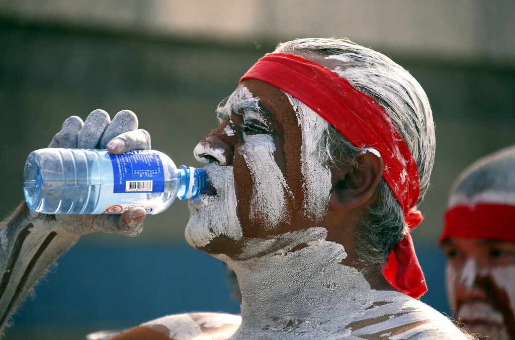 A traditonally dressed Australian Aboriginal performer has a drink of water as he prepares to participate in a 'Corroboree' showcasing traditional dance during an event to mark National Reconciliation Week on Sydney's Coogee Beach May 27, 2015. REUTERS/David Gray - GF10000108521