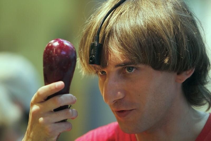 British cyborg musician and performer Neil Harbisson poses while holding an eggplant in Palma de Mallorca on the Spanish Balearic island of Mallorca September 9, 2011. Harbisson, who was born with achromatopsia, a condition that only allows him to see in black and white, became in 2004 the first person in the world to be fitted with an eyeborg. The eyeborg works with a head-mounted camera that picks up the colours in front of it and converts them in into sound waves. By memorising the frequencies related to each colour, Harbisson can perceive up to 36 colors.