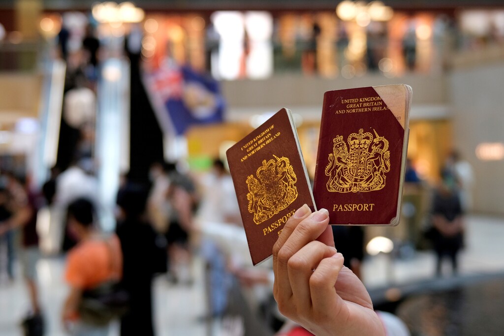 A traveller holds up an old and new British passport.
