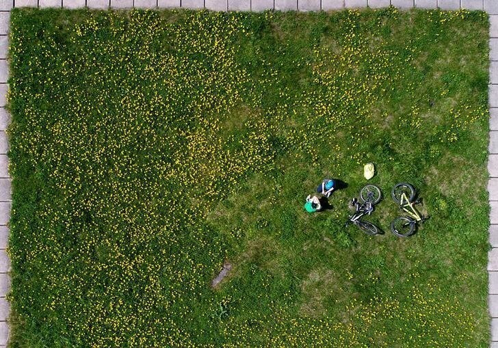 An aerial view shows children playing on the grass in the Siberian town of Divnogorsk, Russia June 6, 2018. REUTERS/Ilya Naymushin TPX IMAGES OF THE DAY