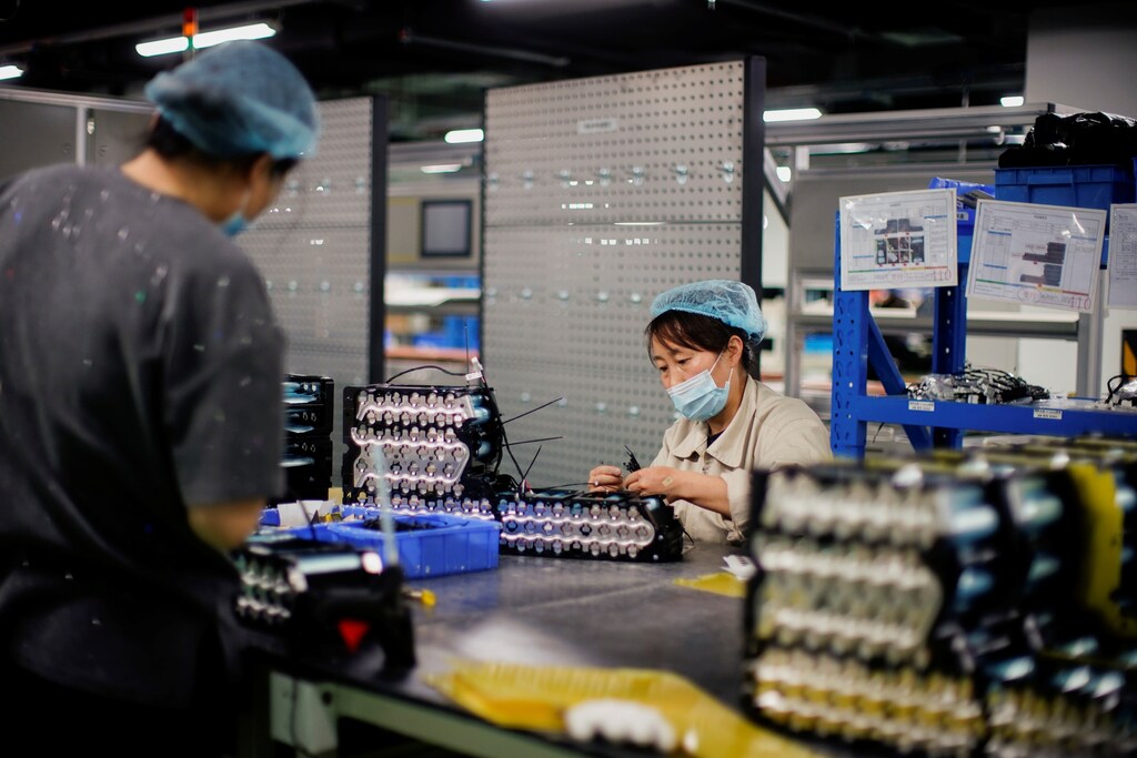 Employees work on the production line of electric vehicle (EV) battery manufacturer Octillion in Hefei, Anhui province, China March 30, 2021. Picture taken March 30, 2021. REUTERS/Aly Song