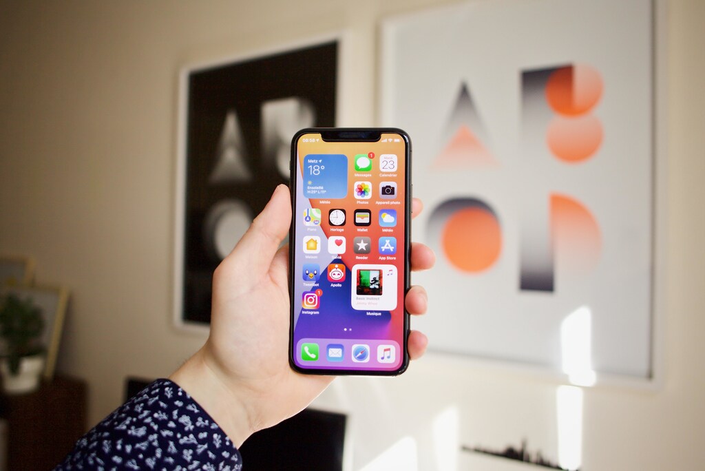 A person holding their iPhone. Smartphone companies are racing to bring us products which will let us use a satellite connection when we’re out of reach of Wi-Fi and cellular networks.