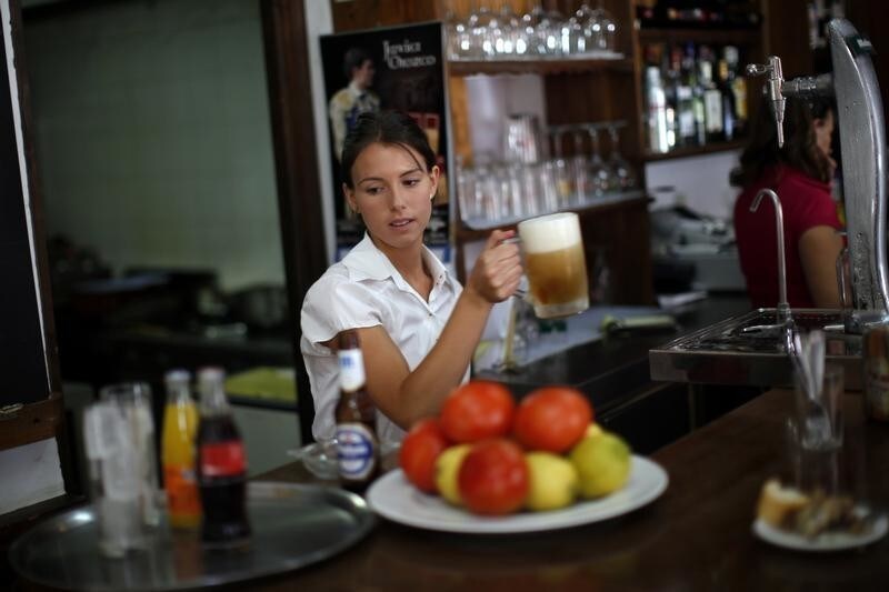 Olalla Gomez, 22, a final-year student of English philology who is also on on the first day of her probation period before getting a contract as temporary waiter, holds a mug of beer in the "Los Capeas" restaurant in downtown Ronda, near Malaga, southern Spain July 24, 2014. Spain's unemployment rate fell to its lowest level in two years in the second quarter, data showed on Thursday, lifted by strong job creation in the services sector and adding to hopes of a sustained economic turnaround. Unemployment fell to 24.5 percent from 25.9 percent a quarter earlier, the National Statistics Institute said. The headline figure remains the second highest in Europe, but the drop was steeper than expected as more than 400,000 people started work, the largest quarterly increase since the second quarter of 2005.