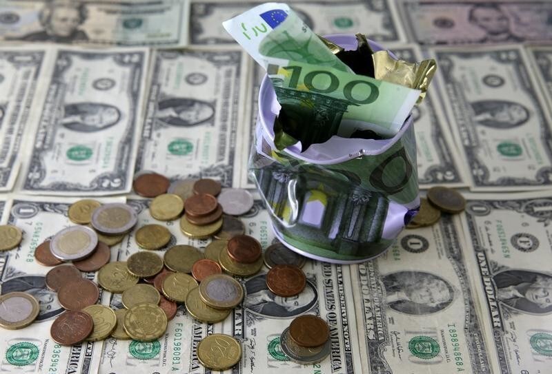 Dollar banknotes and Euro banknote and coins are seen in front of destroyed Euro saving money box in this picture illustration taken February 16, 2017.