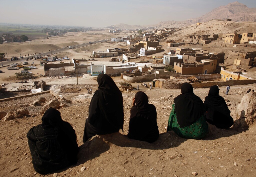 A group of women villagers watches from the hill-top as bulldozers move in to start demolishing the village of Gurna, built on top of ancient tombs near the southern city of Luxor December 2, 2006. Bulldozers moved in on Saturday to start demolishing Gurna, which lies on top of an ancient necropolis. REUTERS/Goran Tomasevic (EGYPT) - GM1DUBNHXZAA