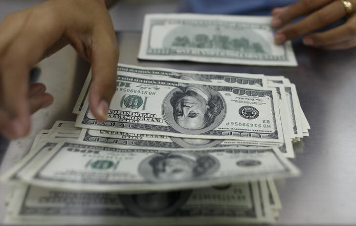 A woman counts U.S. dollars at a money changer in Yangon May 23, 2013. Myanmar's currency has plunged more than 7 percent over the past month to the lowest since it was floated last year, raising concern about economic stability in Asia's newest democracy. Picture taken May 23, 2013. REUTERS/Soe Zeya Tun (MYANMAR - Tags: BUSINESS)