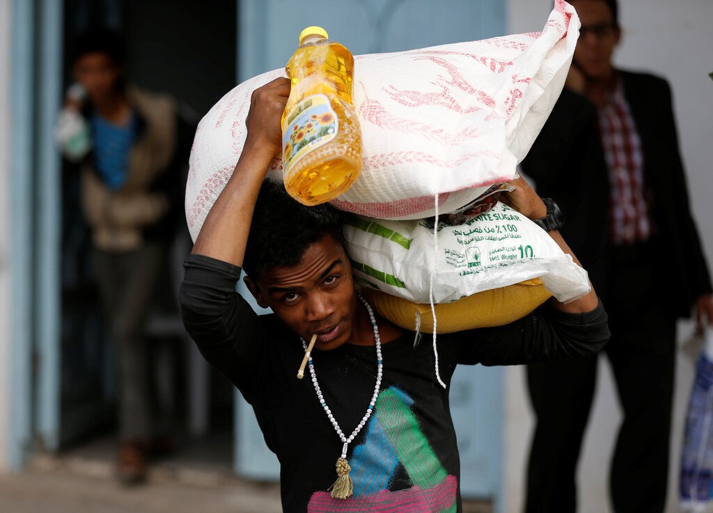 A man carries food aid he received from a local charity during the holy month of Ramadan in Sanaa, Yemen May 31, 2017. REUTERS/Khaled Abdullah - RC11BC679080