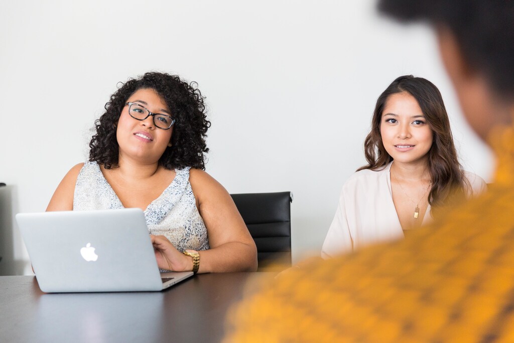 Two women interviewing a candidate for a position.