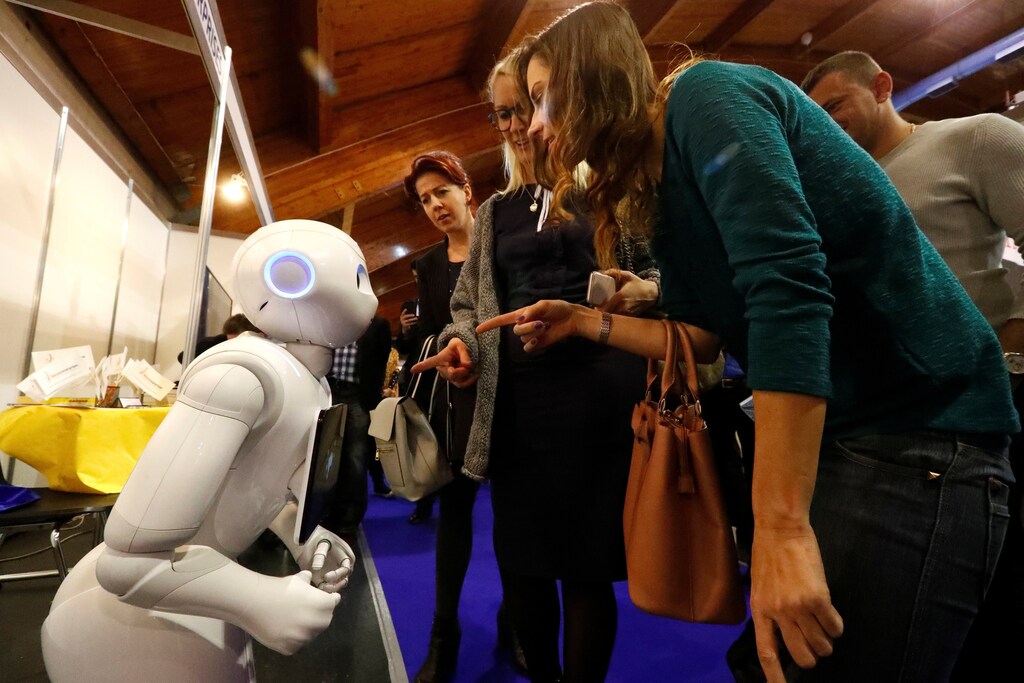 Women communicate with the humanoid robot Pepper during Riga Comm 2017, a business technology and innovation fair in Riga, Latvia November 9, 2017. REUTERS/Ints Kalnins - RC1E49CBBB70