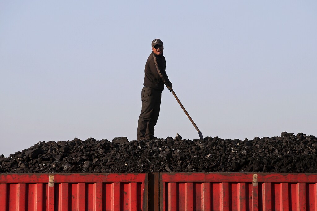 A worker speaks as he loads coal on a truck at a depot near a coal mine from the state-owned Longmay Group on the outskirts of Jixi, in Heilongjiang province, China, October 24, 2015. To match story CHINA-COAL/JIXI Picture taken on October 24, 2015. REUTERS/Jason Lee - GF20000045461