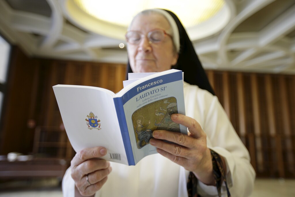 A nun reads Pope Francis' new encyclical titled 'Laudato si' at the Vatican June 18, 2015. Pope Francis demanded swift action on Thursday to save the planet from environmental ruin, urging world leaders to hear "the cry of the earth and the cry of the poor", plunging the Catholic Church into political controversy over climate change. In the first papal document dedicated to the environment, he calls for "decisive action, here and now," to stop environmental degradation and global warming, squarely backing scientists who say it is mostly man-made. REUTERS/Max Rossi TPX IMAGES OF THE DAY - GF10000131581