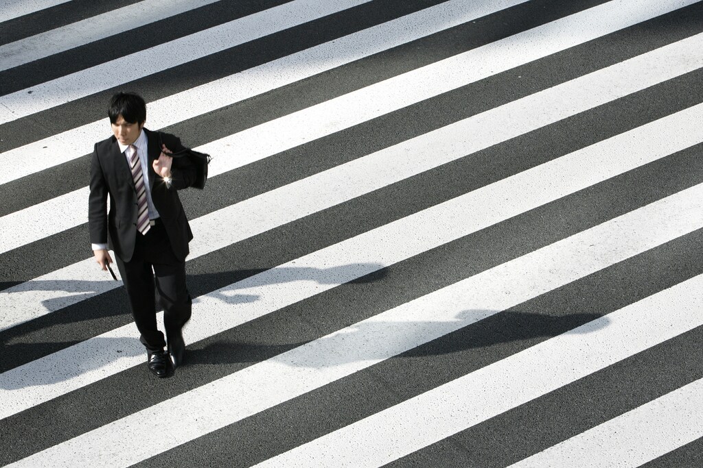 A man crosses a street in Tokyo August 3, 2009. REUTERS/Stringer (JAPAN BUSINESS EMPLOYMENT) - GM1E58J0VUT01
