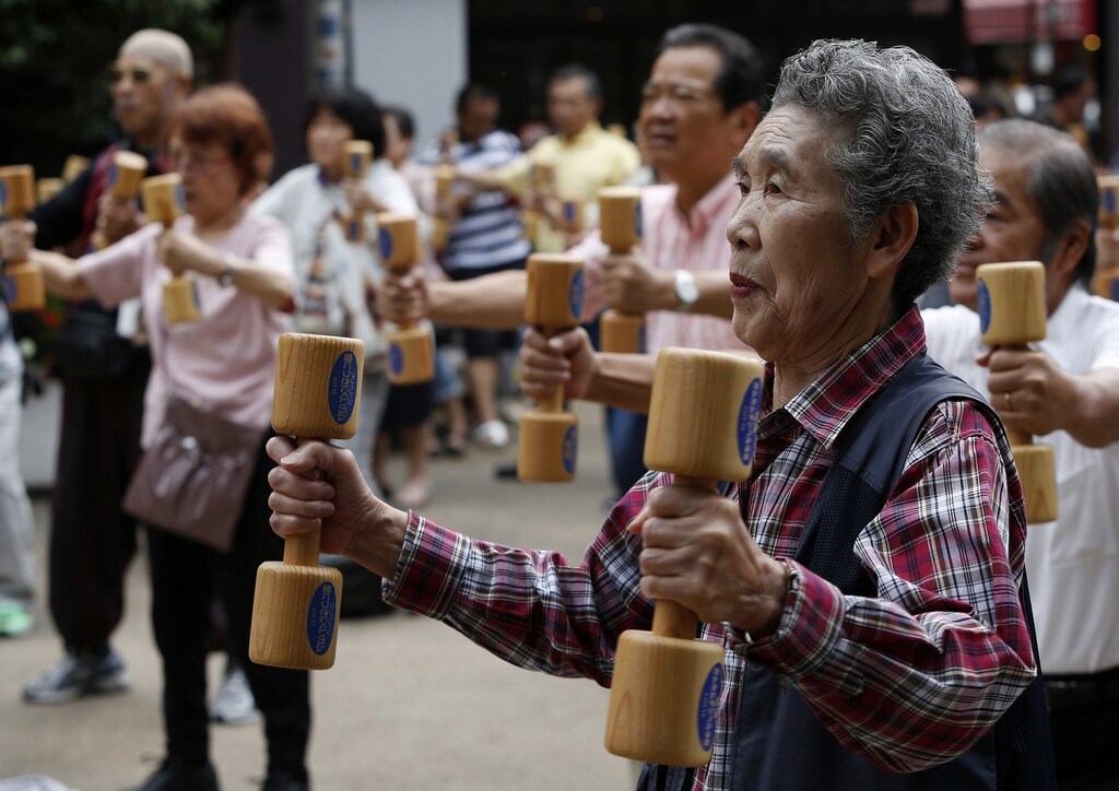 People use wooden dumbbells during a health promotion event to mark Japan's "Respect for the Aged Day" at a temple in Tokyo's Sugamo district, an area popular among the Japanese elderly, September 15, 2014. The population aged over 65 in Japan reaches about 33 million, which is the highest number in the history meaning one out of every four people is 65 or older, according to the government survey. REUTERS/Yuya Shino (JAPAN - Tags: SOCIETY HEALTH SPORT) - RTR467JR