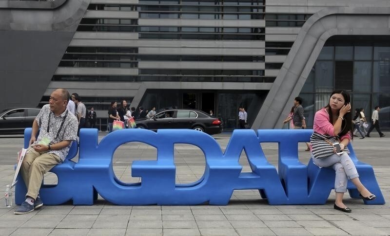 Visitors sit on a bench made in the shape of "Big Data" outside the venue of the 2015 Big Data Expo in Guiyang, Guizhou province, China, May 26, 2015.