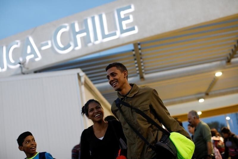 Adrian Naveda, Alejandra Rodriguez and her nephew David Vargas (R-L), traveling by bus from Caracas to Chile, smile after crossing the border between Peru and Chile at the migration office in Arica, Chile, November 13, 2017. Getting to Chile was the goal, but everyone was a little worried, because they knew this was the border where the authorities could ask them tricky questions. As they walked out of the migration office in Arica, happiness and a mood of "We made it!" took over, even though they still had two more days on the road ahead of them. REUTERS/Carlos Garcia Rawlins SEARCH "RAWLINS BUS" FOR THIS STORY. SEARCH "WIDER IMAGE" FOR ALL STORIES. - RC12F2B3EB90