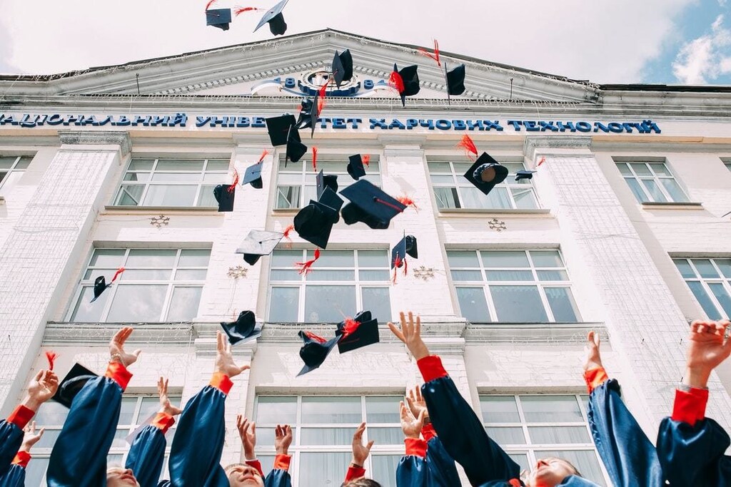 jobs: Graduates throw their graduate caps into the air.