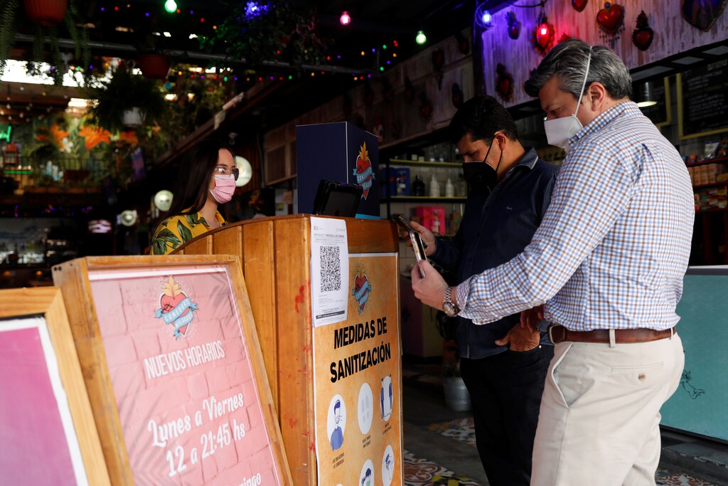 Customers register before entering the restaurant Comedor de los Milagros after the city government implemented a QR-code registration system to prevent novel coronavirus spread in Mexico City, Mexico November 25, 2020. REUTERS/Henry Romero - RC2QAK98MXWD