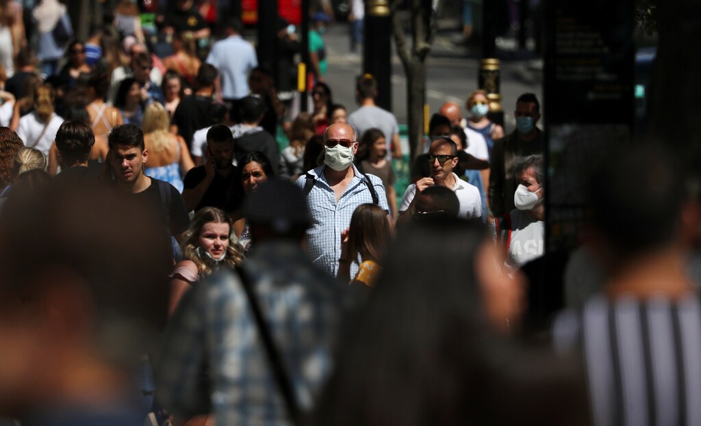 A man wearing a face mask is pictured among a crowd in Oxford Street, following the coronavirus disease (COVID-19) outbreak, in London, Britain, July 18, 2020. REUTERS/Simon Dawson - RC2QVH9PV8MP