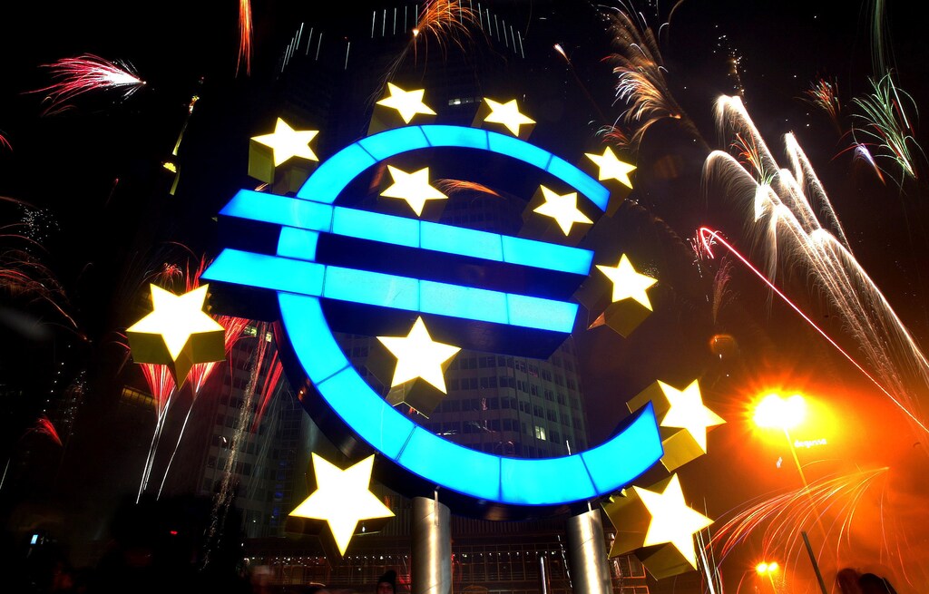 Fireworks illuminate the sky around a huge euro sculpture, designed by German artist Ottmar Hoerl, in front of the headquarters of the European Central Bank (ECB) in Frankfurt, January 1, 2002. Several thousand people in Frankfurt celebrated at a party on the streets around the ECB to welcome Europe's new currency, the euro. UNICS REUTERS/Kai Pfaffenbach REUTERS KP - RP3DRIFSZXAA
