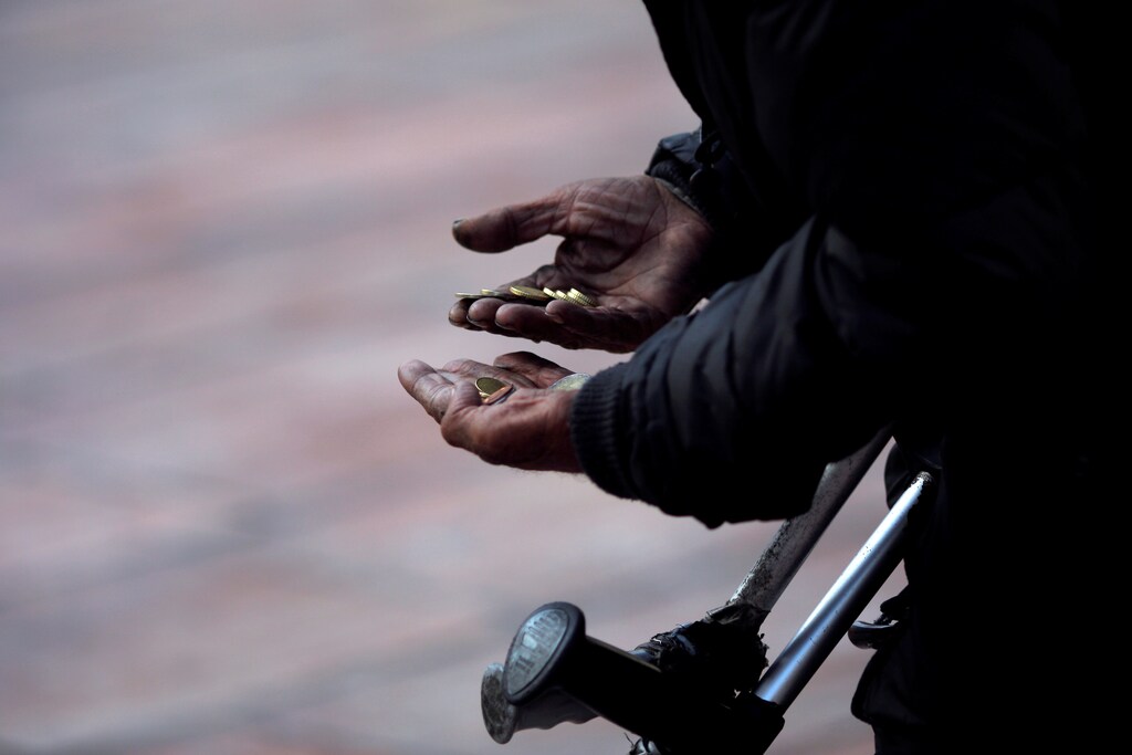 A beggar counts coins as he asks for alms during the International Day for the Eradication of Poverty in downtown Malaga, Spain October 17, 2016. REUTERS/Jon Nazca - RTX2P89S