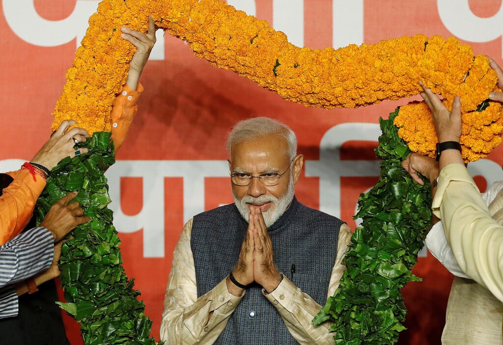 Indian Prime Minister Narendra Modi gestures as he is presented with a garland by Bharatiya Janata Party (BJP) leaders after the election results in New Delhi, India, May 23, 2019. REUTERS/Adnan Abidi TPX IMAGES OF THE DAY - RC1BBC590B00