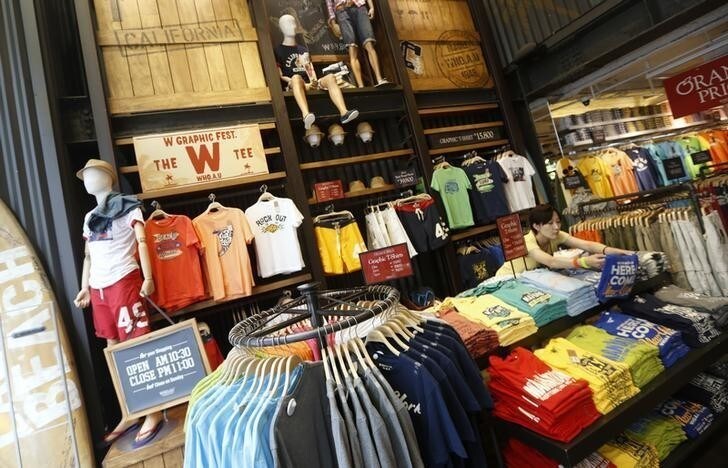 An employee arranges clothes in a shop housing one of the apparel brands of E-Land Group, in Seoul June 24, 2013. Since its humble beginnings near the turn of the 20th century, mainstream Korean brands got their start in the jungle-like bazaar. Privately owned E-Land Group is now leading Korean fashion brands' overseas expansion. Picture taken June 24, 2013. REUTERS/Lee Jae-Won (SOUTH KOREA - Tags: BUSINESS)