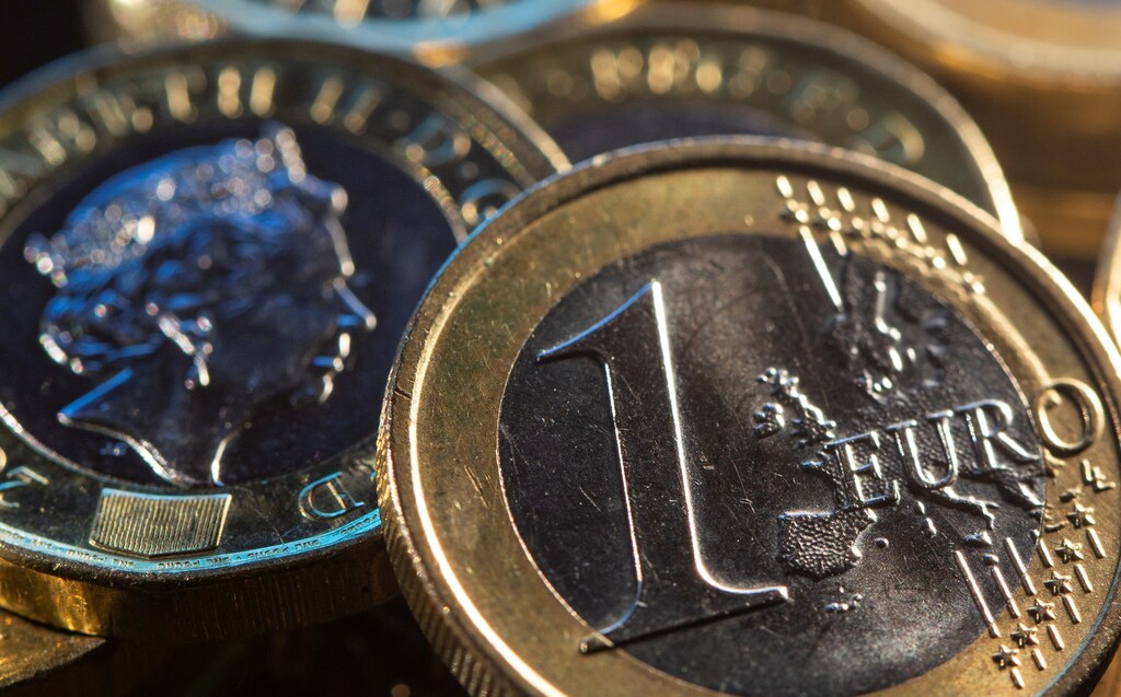 One Euro and a British pound coin are seen.