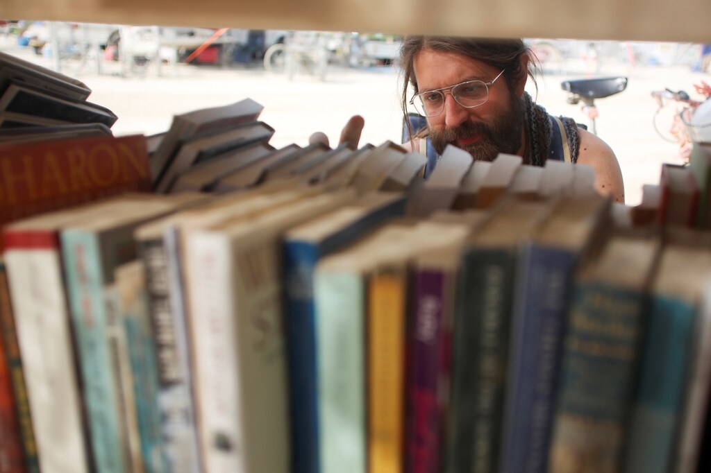 Dario Clocchiatti looks for a book at one of the temporary libraries on the "Playa" as approximately 70,000 people from all over the world gather for the 30th annual Burning Man arts and music festival in the Black Rock Desert of Nevada, U.S. September 3, 2016. REUTERS/Jim Urquhart FOR USE WITH BURNING MAN RELATED REPORTING ONLY. FOR EDITORIAL USE ONLY. NOT FOR SALE FOR MARKETING OR ADVERTISING CAMPAIGNS. NO THIRD PARTY SALES. NOT FOR USE BY REUTERS THIRD PARTY DISTRIBUTORS - RTX2O0D2
