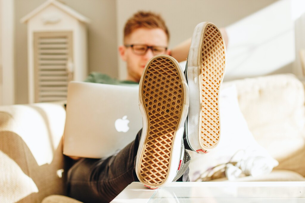 A man working on a laptop, with his feet up.