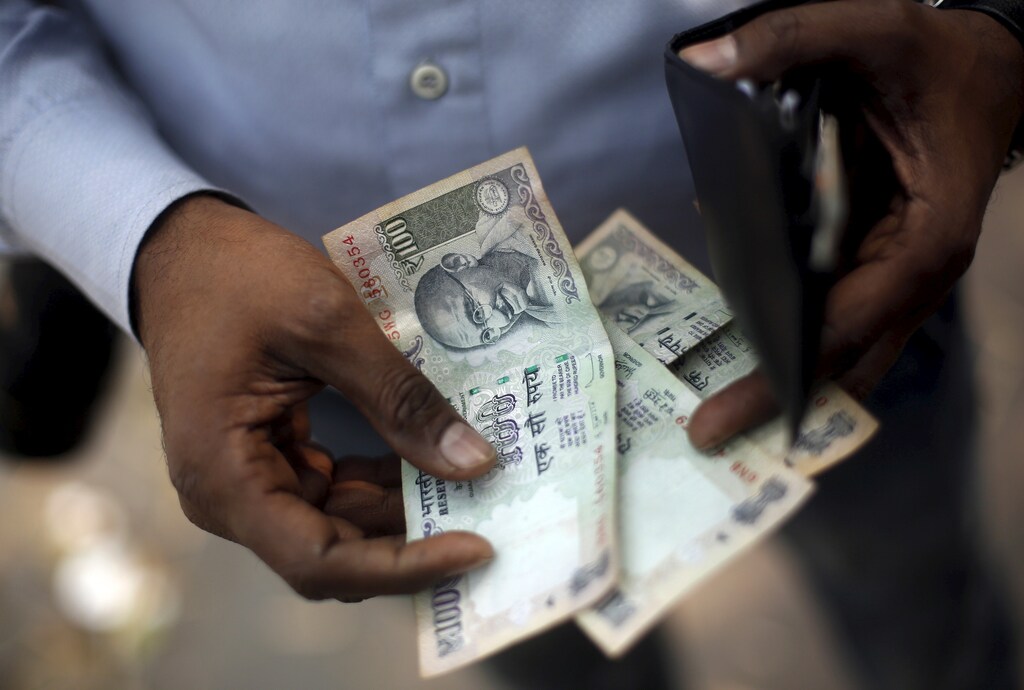 A man counts his currency after buying food from a street side restaurant in New Delhi, India, February 29, 2016. India unveiled a fire-fighting budget on Monday that seeks to win back support among rural voters for Prime Minister Narendra Modi's government and sustain growth against a grim global backdrop - all without borrowing more. REUTERS/Adnan Abidi - GF10000328044