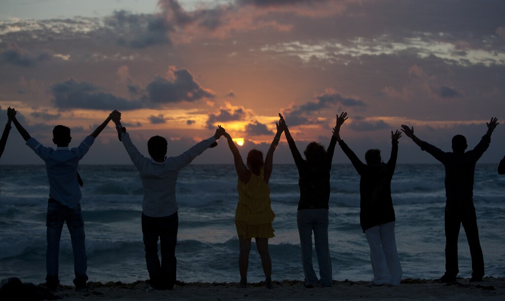 People raise their hands on a beach during the dawn of New Year's Day in Cancun January 1, 2012. REUTERS/Victor Ruiz Garcia (MEXICO - Tags: SOCIETY ANNIVERSARY) - GM1E8111SLL01