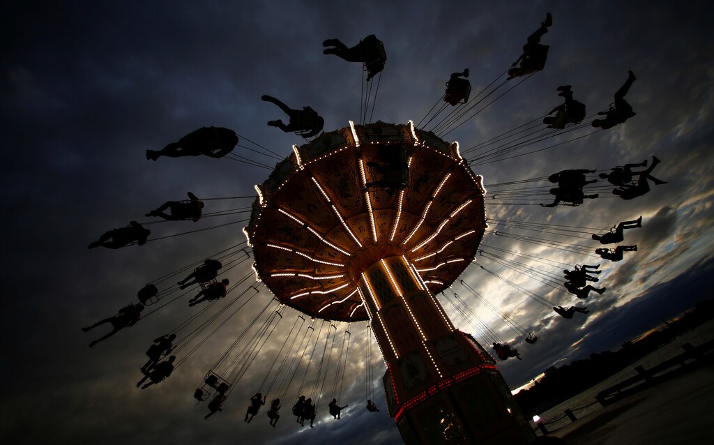 People ride on a merry-go-round carousel during sunset in Stockholm, Sweden, August 16, 2016.
