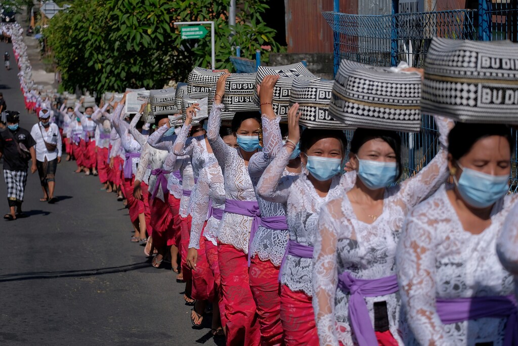 Balinese Hindus wearing protective masks carry offerings as they celebrate the Galungan religious holiday at Lukluk village, amid the coronavirus disease (COVID-19) pandemic, in Badung, Bali, Indonesia April 14, 2021. Nyoman Hendra Wibowo/Antara Foto via REUTERS ATTENTION EDITORS - THIS IMAGE WAS PROVIDED BY THIRD PARTY. MANDATORY CREDIT. INDONESIA OUT. TPX IMAGES OF THE DAY - RC2PVM9K2L4J